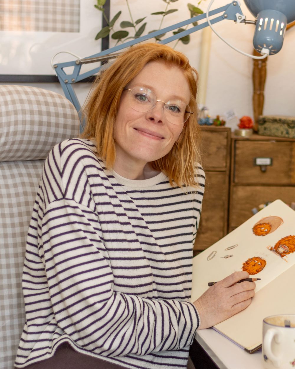 Nadine Dreyer am Zeichentisch mit Skizzenbuch und Stift